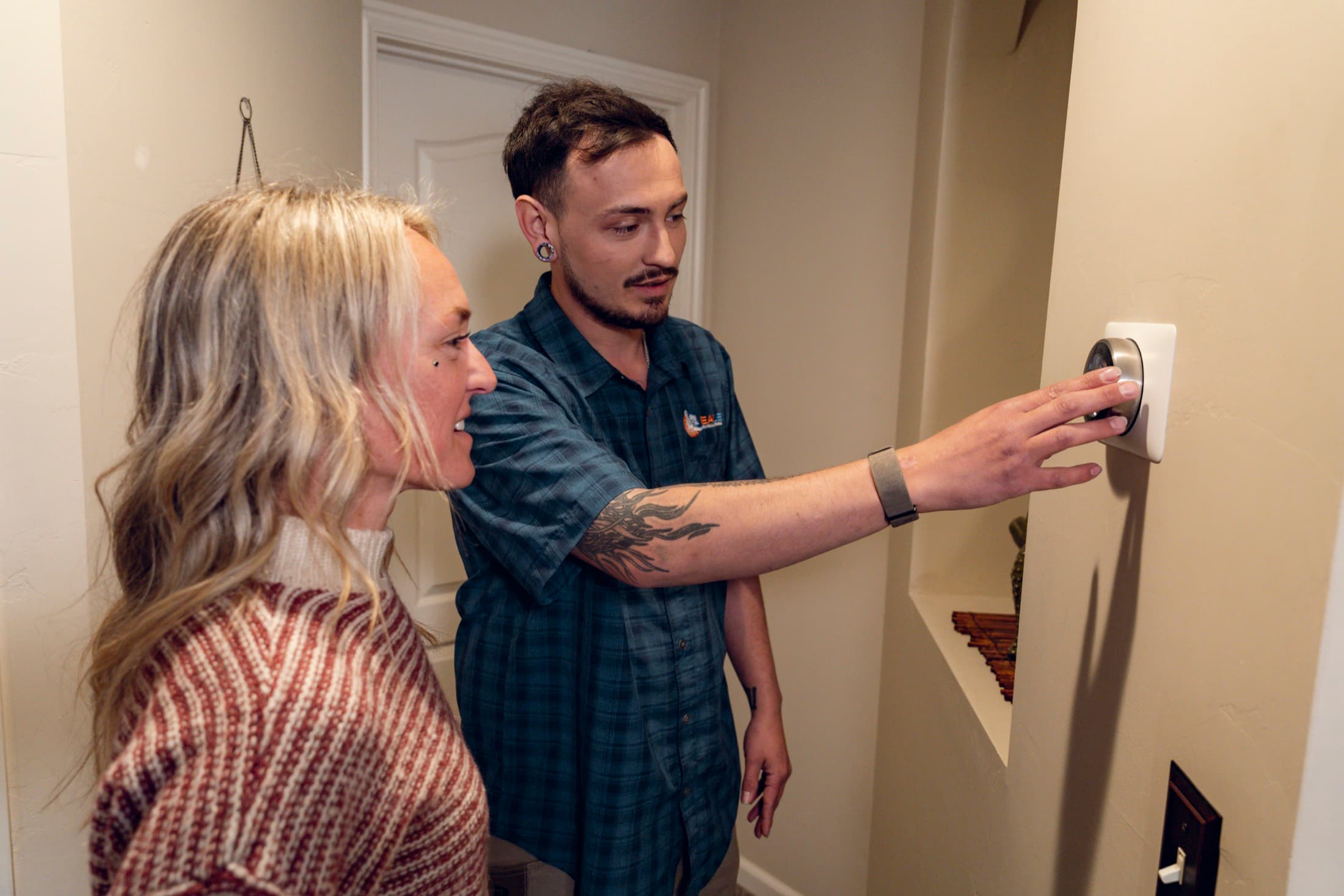 Eagle Heating and Air technician checking indoor comfort controls